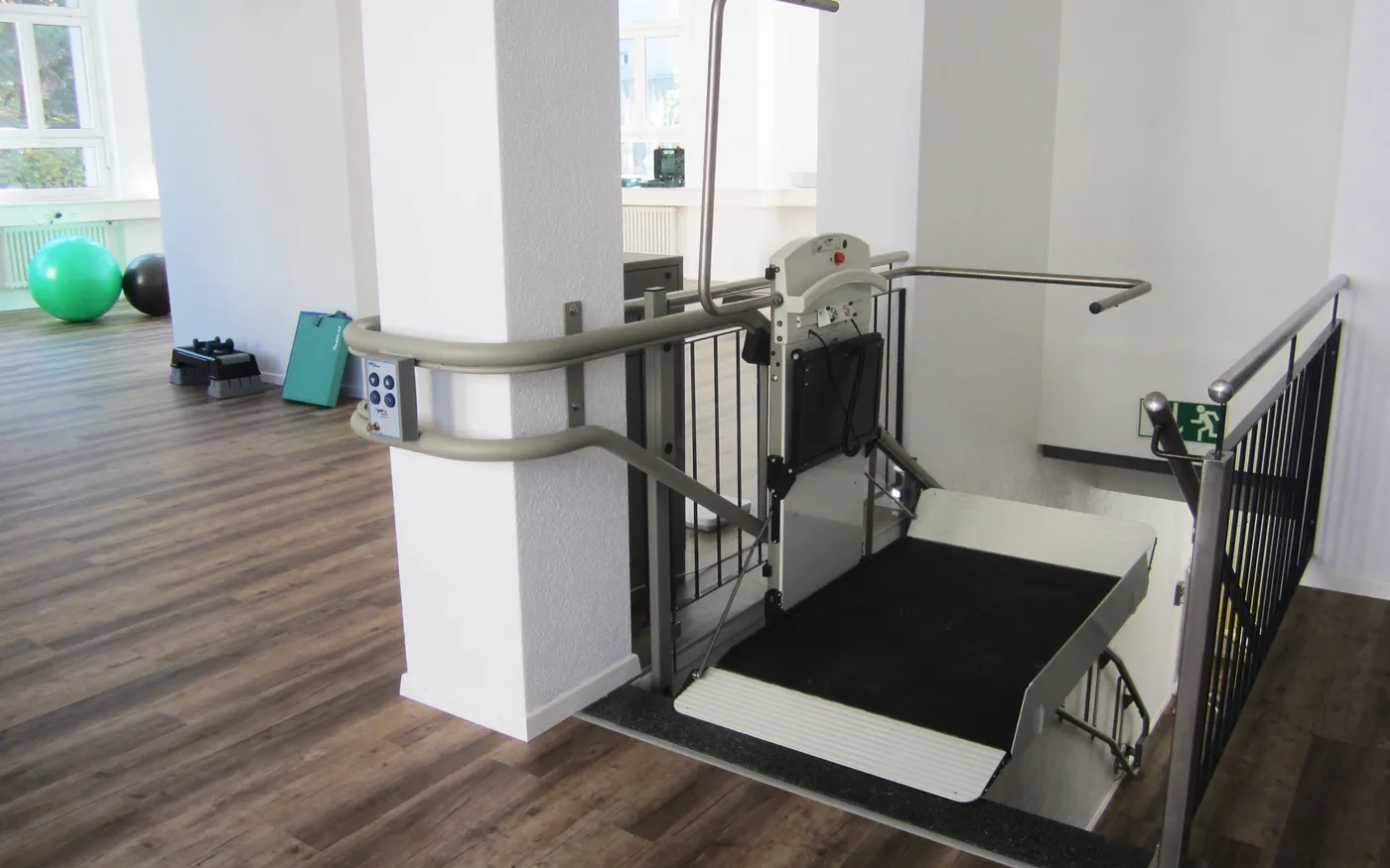 Une plateforme élévatrice inclinée pour fauteuil roulant, installée le long d’un escalier